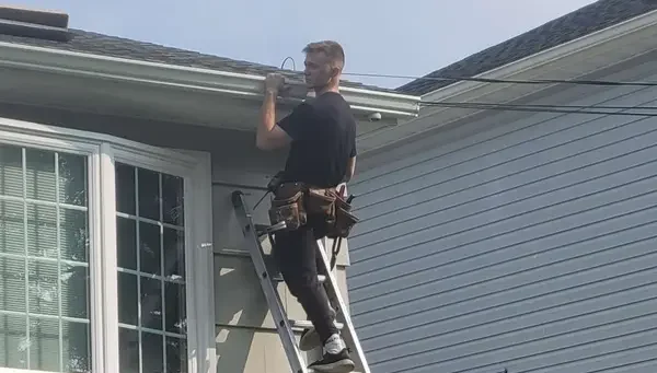 John's son working on gutter installation, representing the next generation of quality craftsmanship at Tri State Gutters